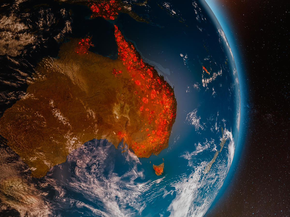 View from space looking down at planet earth. A portion of the land is covered in bright red and orange wildfires.