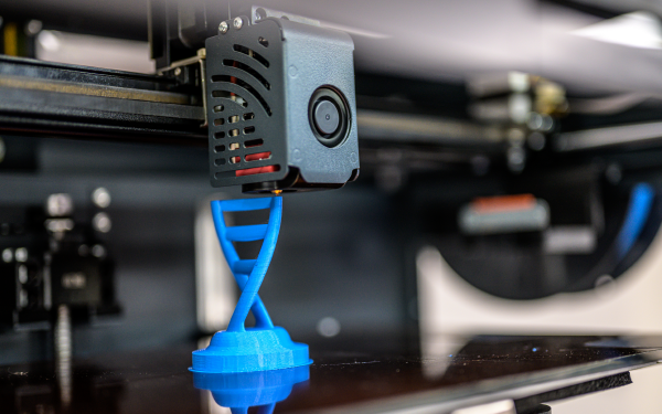 3D printer printing blue DNA strand.
