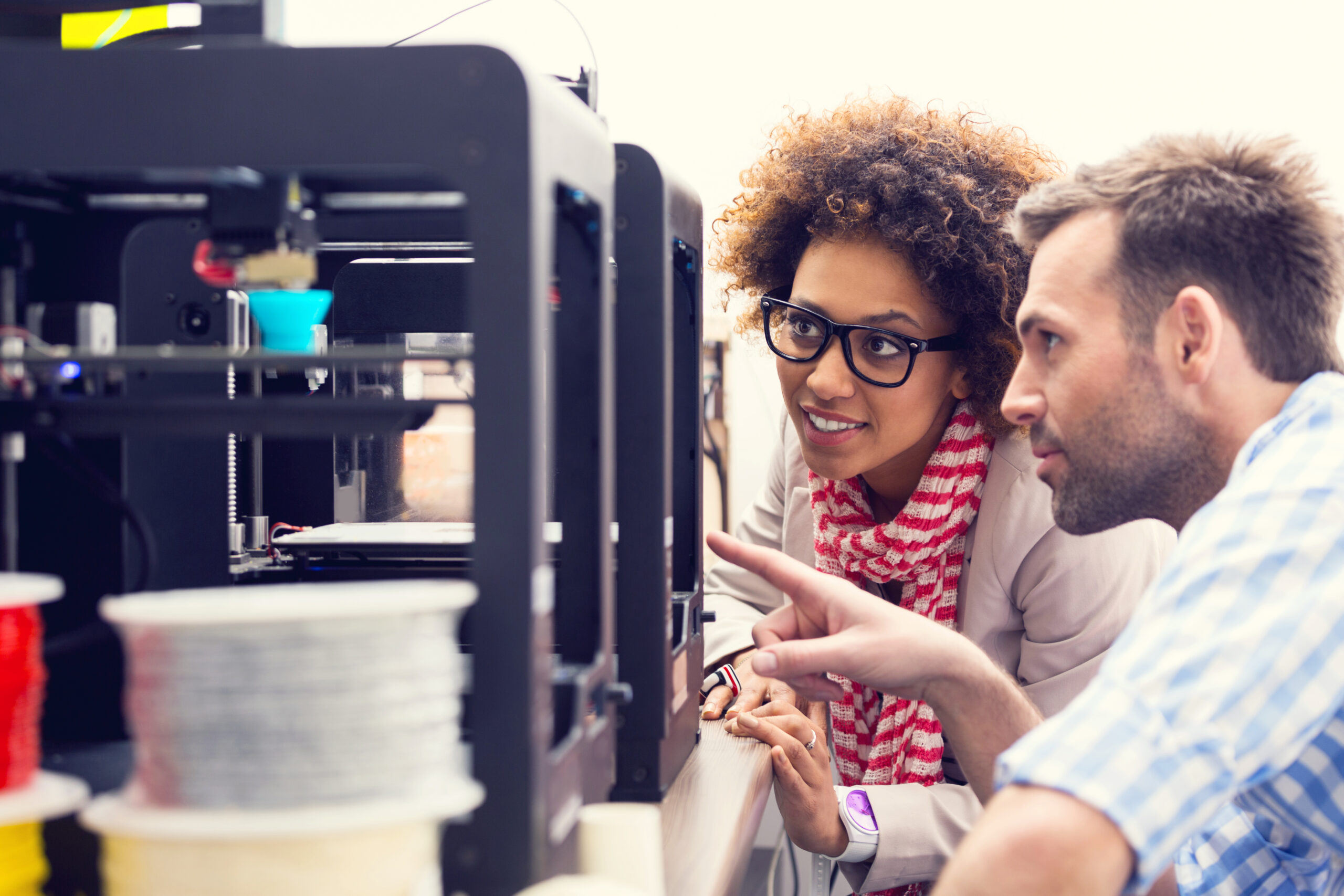 Two business colleagues working together in a 3d printer office.